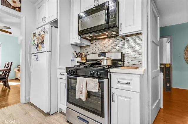 a kitchen with stainless steel appliances granite countertop a stove microwave and refrigerator