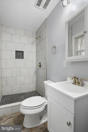 a bathroom with a sink a toilet and shower