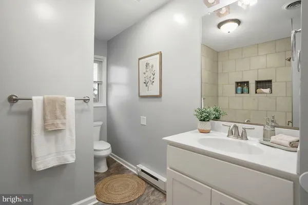 a bathroom with a granite countertop sink toilet and shower
