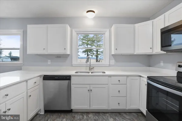a kitchen with white cabinets stainless steel appliances and sink