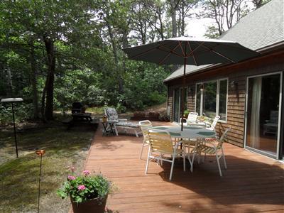 160 Old Long Pond Road Wellfleet, MA 02667 - Photo 7 of 18 a view of a patio with table and chairs under an umbrella