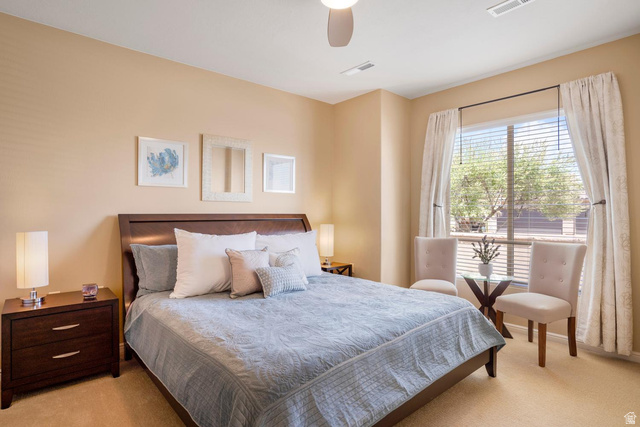 1587 Whitestone Drive St. George, UT 84790 - Photo 16 of 36 Carpeted bedroom featuring a ceiling fan, a large window with blinds and drapes, and a built-in wall niche