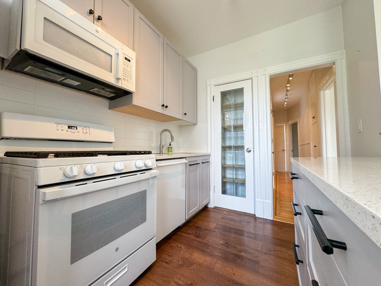 a kitchen with granite countertop cabinets stainless steel appliances and a wooden floor