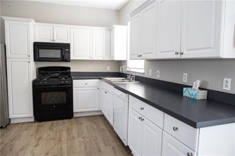 344 Bushkill Street, Unit 2 Easton, PA 18042 - Photo 18 of 30 A well-lit culinary space showcases abundant white cabinetry and durable dark countertops.
