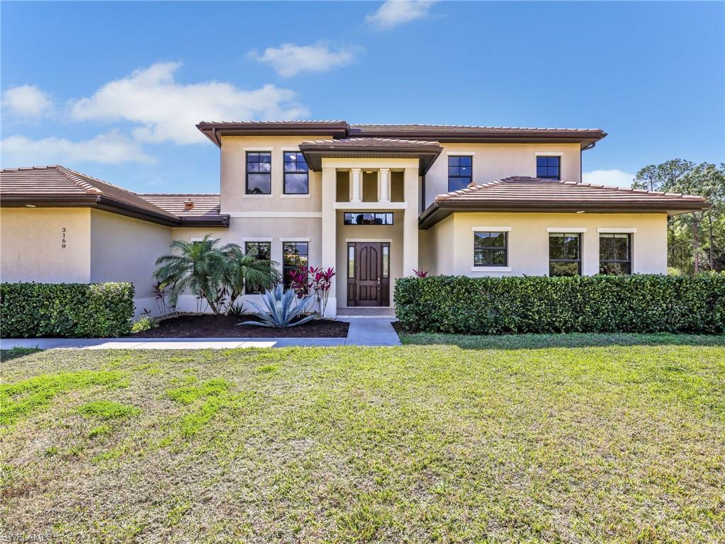 3160 27th Avenue Southwest Naples, FL 34117 - Photo 3 of 43 a front view of a house with a yard and garage