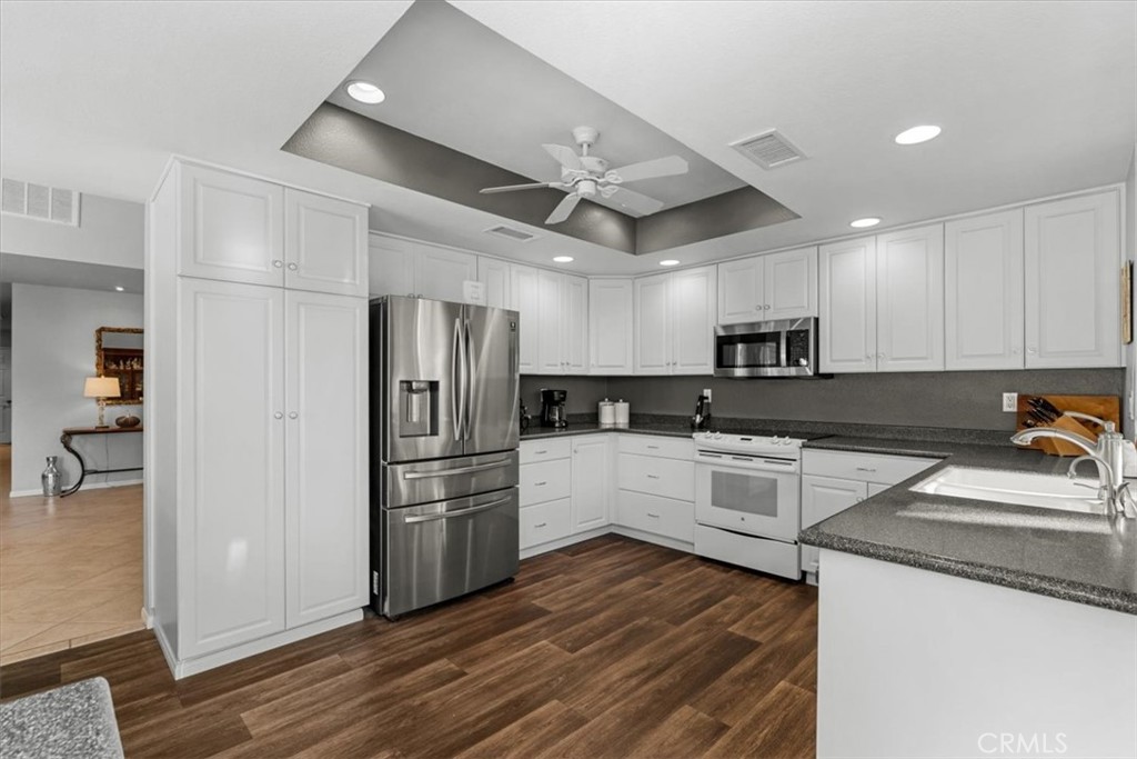 393 Gran Via Palm Desert, CA 92260 - Photo 12 of 60 a kitchen with a refrigerator and white cabinets