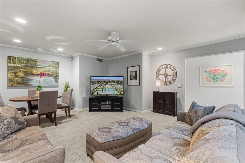 393 Gran Via Palm Desert, CA 92260 - Photo 16 of 60 a living room with furniture a flat screen tv and a fireplace