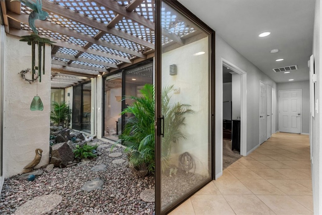 393 Gran Via Palm Desert, CA 92260 - Photo 18 of 60 a view of a hallway with potted plants