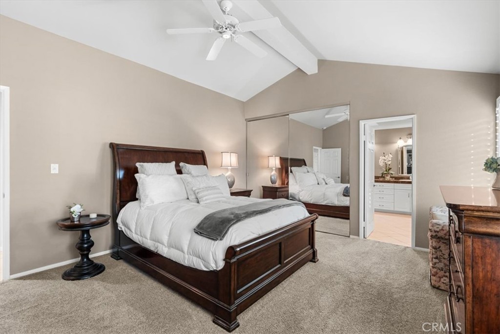 393 Gran Via Palm Desert, CA 92260 - Photo 19 of 60 a spacious bedroom with a bed and a chandelier