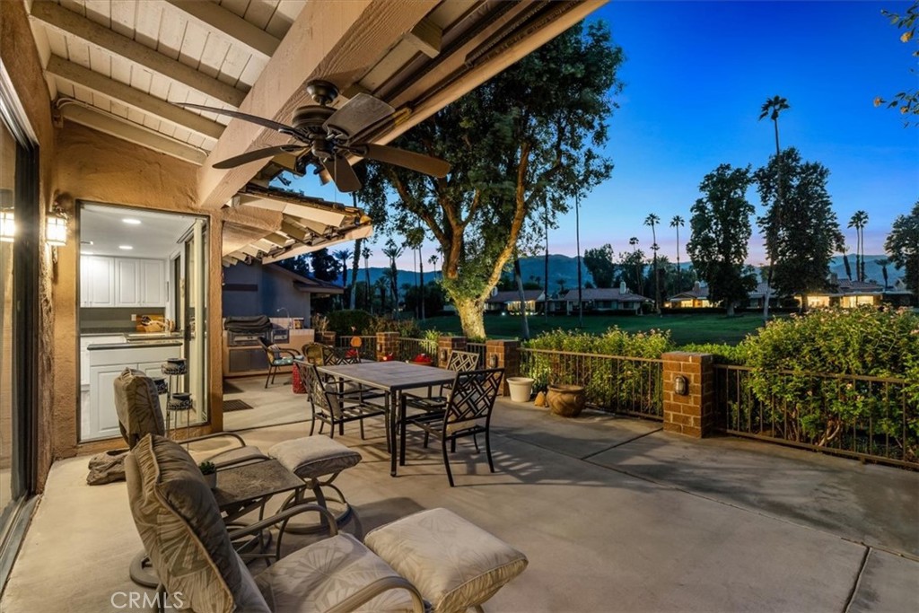 393 Gran Via Palm Desert, CA 92260 - Photo 43 of 60 a patio with a table and chairs and potted plants