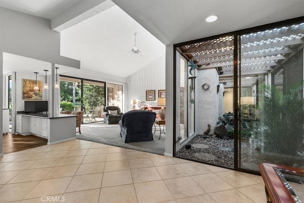 393 Gran Via Palm Desert, CA 92260 - Photo 5 of 60 a living room with furniture a flat screen tv and a floor to ceiling window