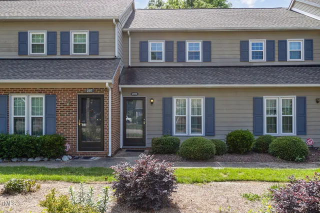 a view of a brick house with potted plants and a large window