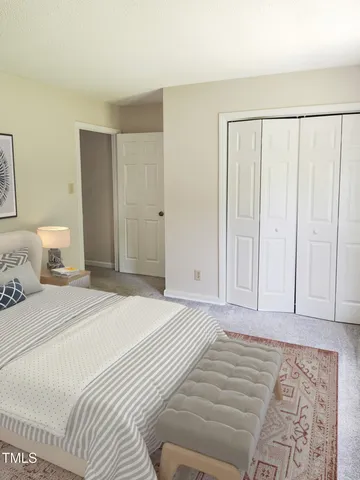 a bedroom with a large bed and a potted plant