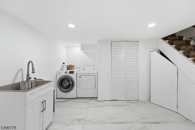 a utility room with sink dryer and washer