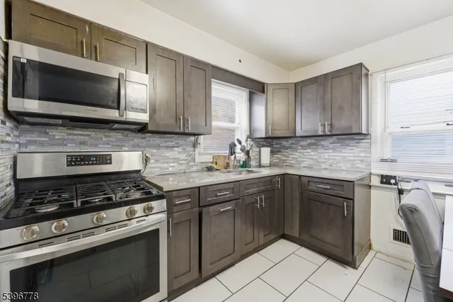 a kitchen with cabinets stainless steel appliances and a window
