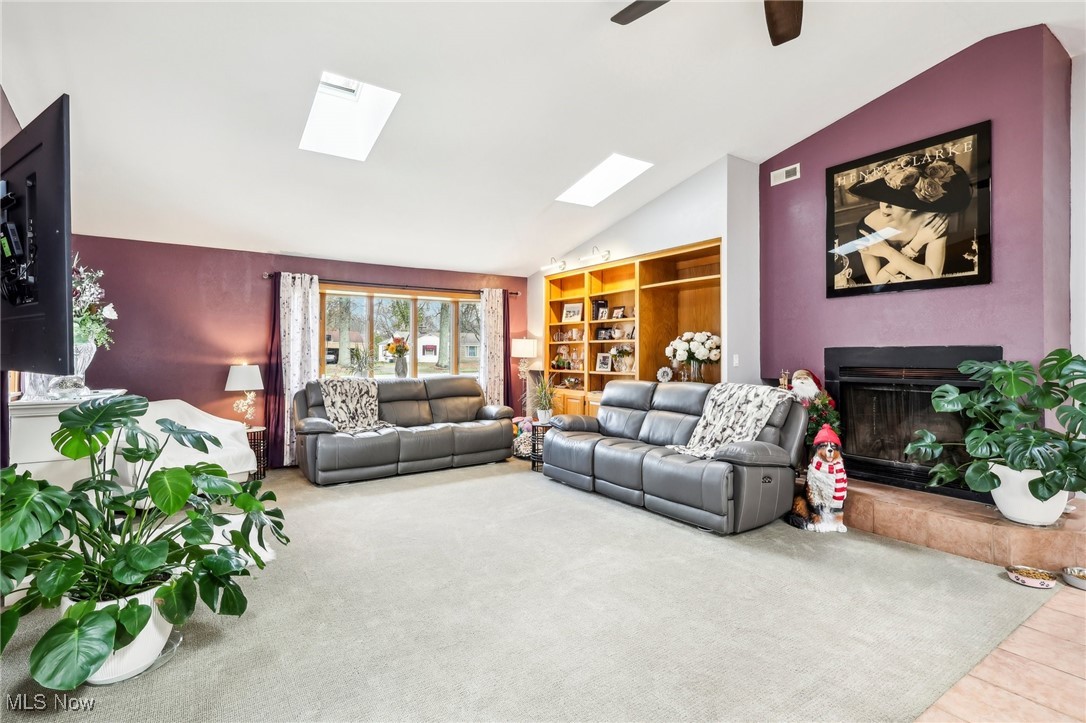 753 Ewing Road Youngstown, OH 44512 - Photo 6 of 47 Living room featuring vaulted ceiling with skylight, ceiling fan, and carpet