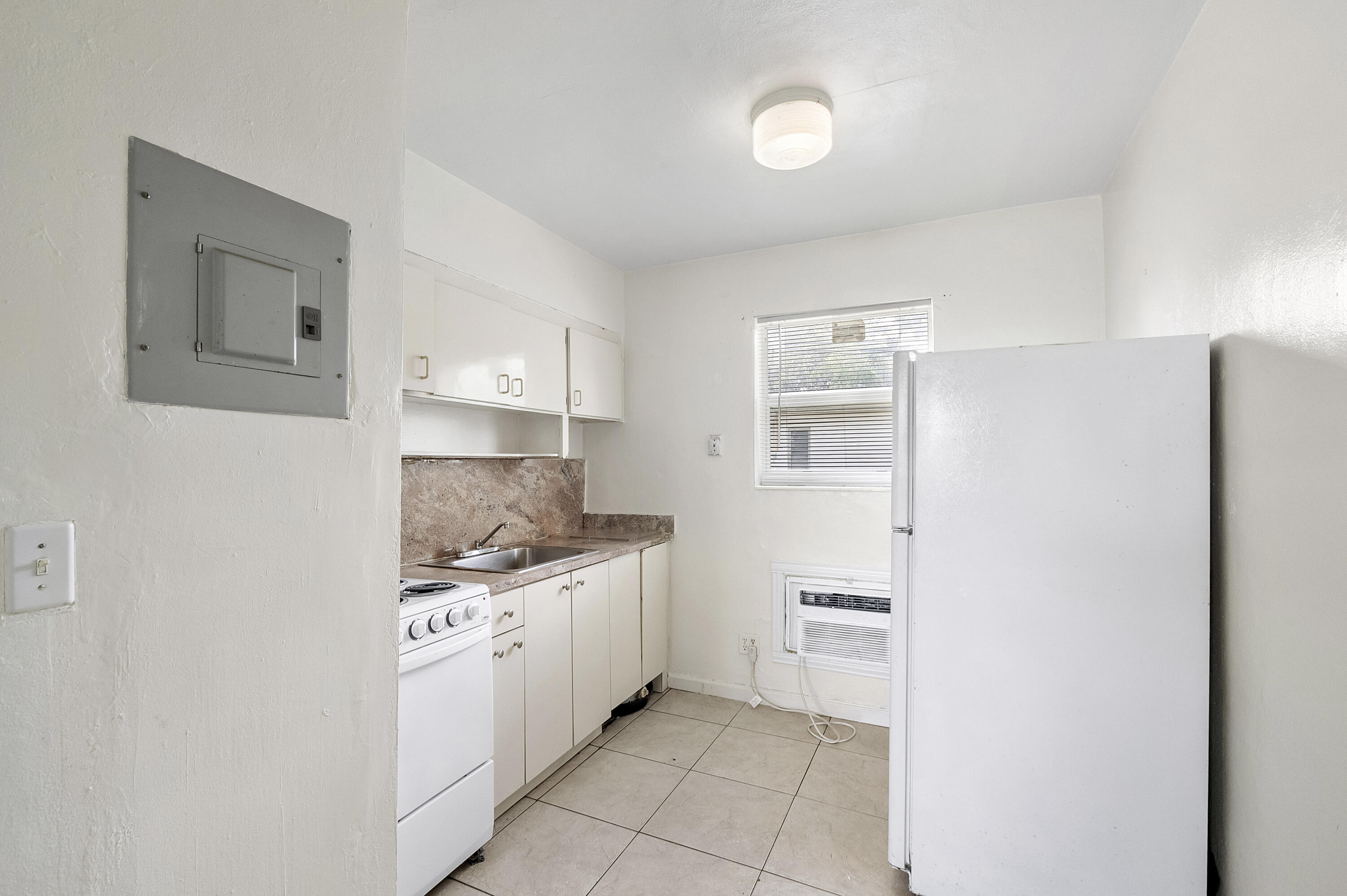 515 Northeast 150th Street, Unit 3 Miami, FL 33161 - Photo 4 of 11 a kitchen with a sink and a stove top oven