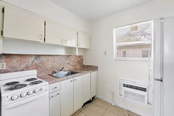 a kitchen with white cabinets and appliances