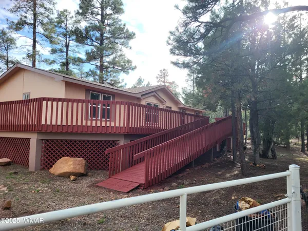 a view of a roof deck with wooden fence and a couple of chairs