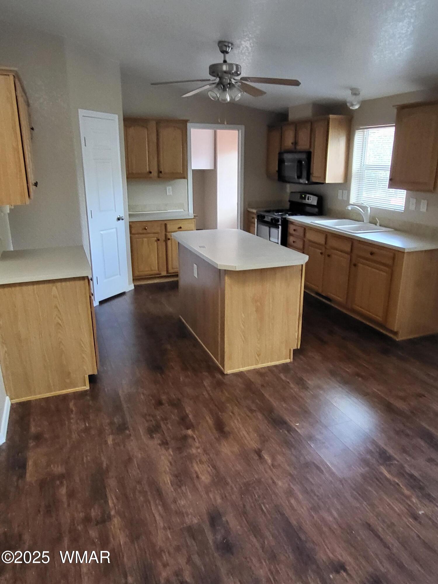 2052 Lone Mountain Road Overgaard, AZ 85933 - Photo 11 of 24 a large kitchen with kitchen island a sink a stove a counter space and a window