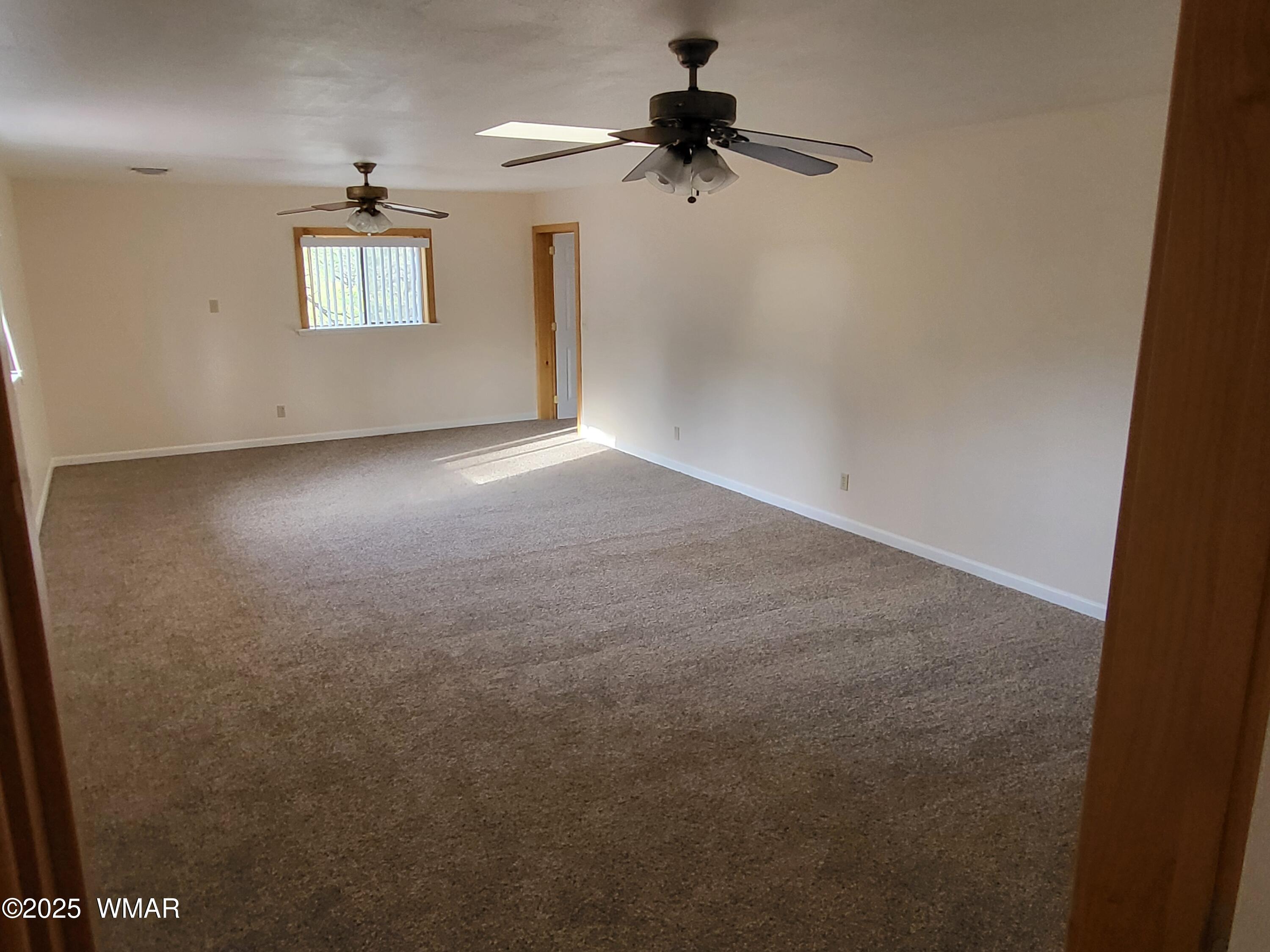 2052 Lone Mountain Road Overgaard, AZ 85933 - Photo 14 of 24 an empty room with windows and fan