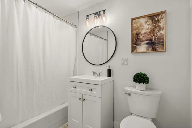 a bathroom with a toilet a sink and a mirror