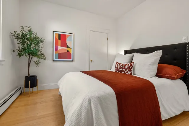a bedroom with bed and a potted plant