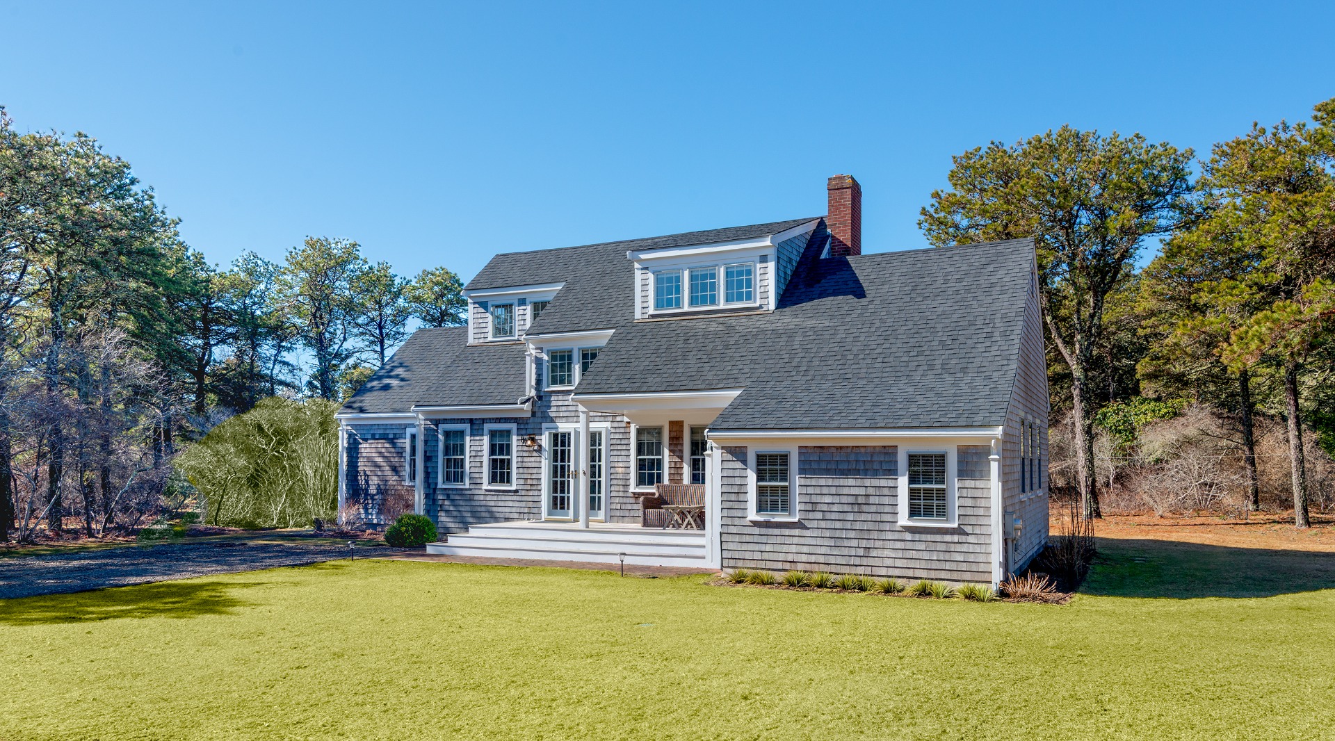 11 Sesapana Road Nantucket, MA 02554 - Photo 1 of 37 a front view of a house with a yard table and chairs