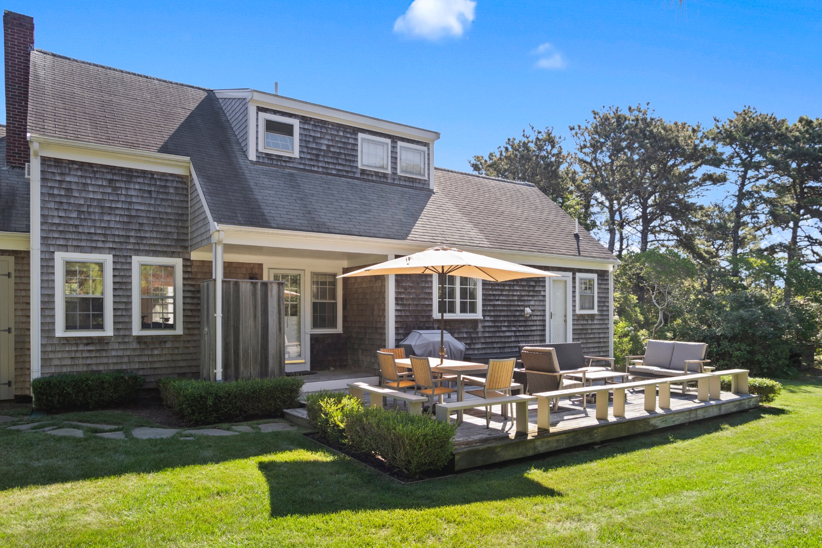 11 Sesapana Road Nantucket, MA 02554 - Photo 30 of 37 a front view of a house with a yard table and chairs