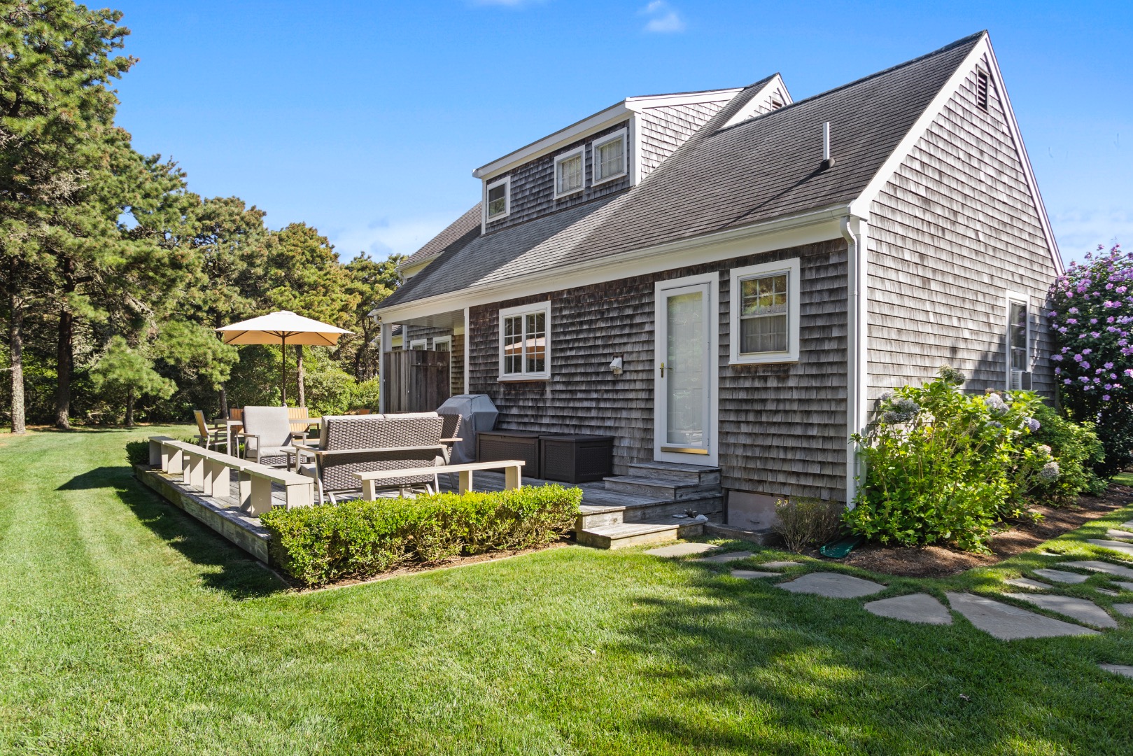 11 Sesapana Road Nantucket, MA 02554 - Photo 31 of 37 a front view of a house with a yard table and chairs