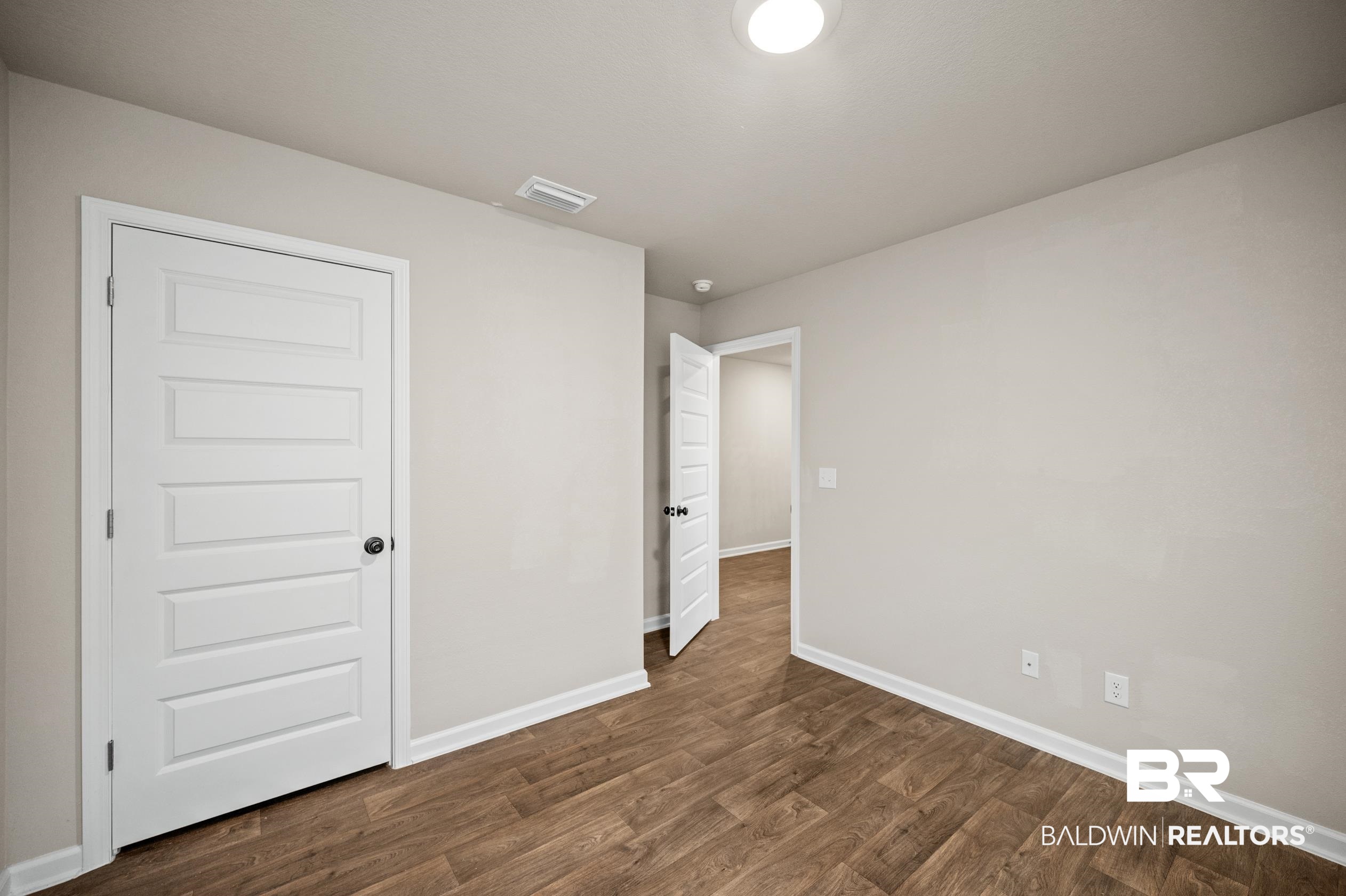 10353 Zenyatta Loop Daphne, AL 36526 - Photo 22 of 33 Unfurnished bedroom featuring dark hardwood / wood-style flooring