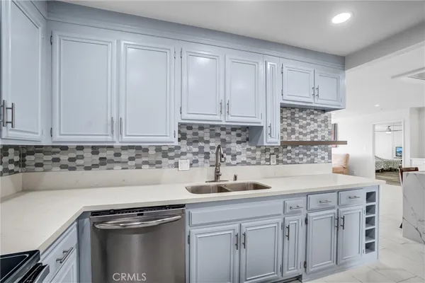 a kitchen with stainless steel appliances granite countertop white cabinets sink and dishwasher