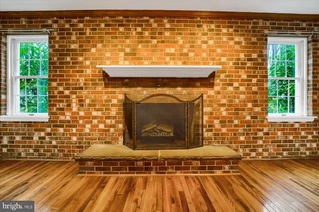 a view of an empty room with a fireplace and a window