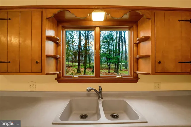 a view of a kitchen with wooden floor and a window