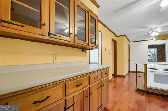 a kitchen with stainless steel appliances white cabinets and wooden floors