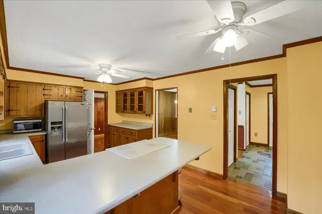 a large kitchen with stainless steel appliances granite countertop a refrigerator and a sink