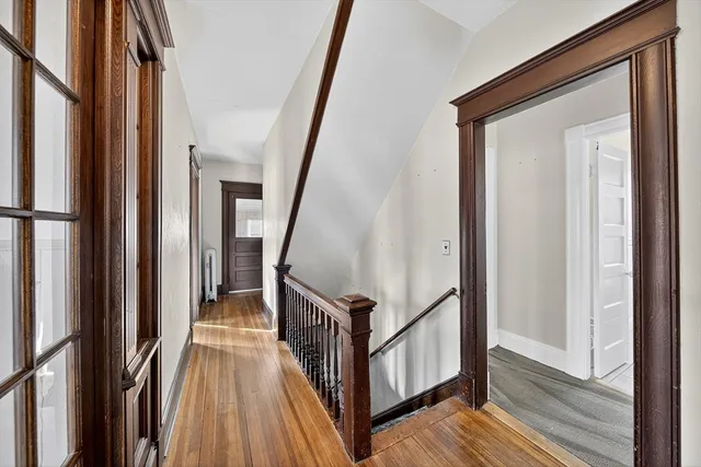 a view of staircase with wooden floor and white walls