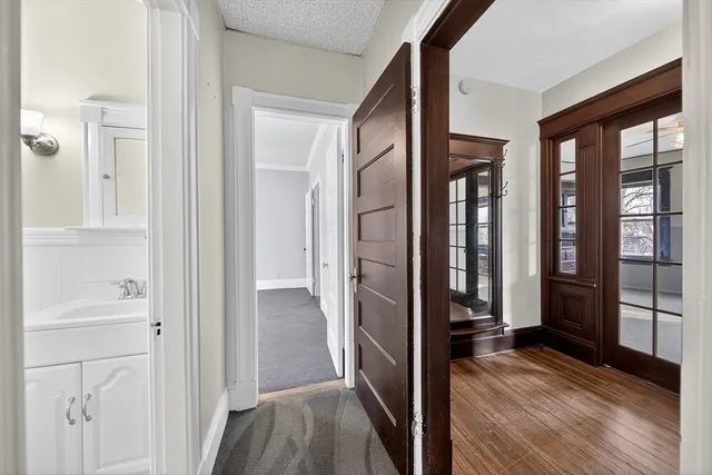 a view of a hallway with wooden floor and staircase