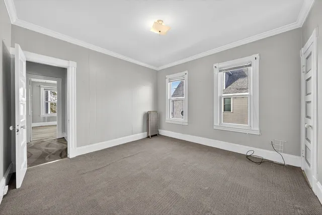 a view of an empty room with window and closet area