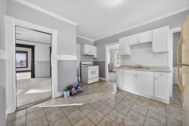 a kitchen with white cabinets and appliances