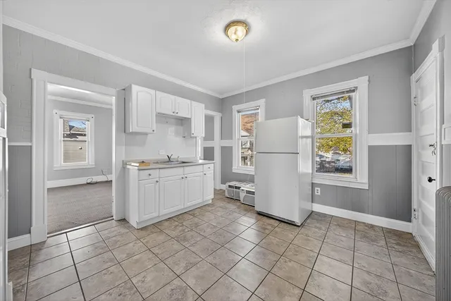 a kitchen with a refrigerator a stove top oven and cabinets