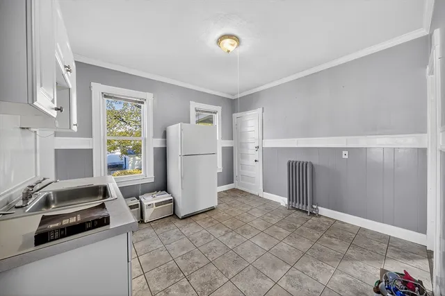 a view of a kitchen with refrigerator and window