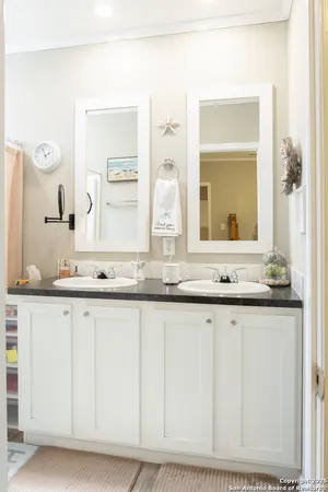 a bathroom with granite countertop white vanity and a mirror