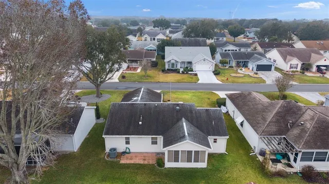 an aerial view of residential houses with outdoor space and swimming pool