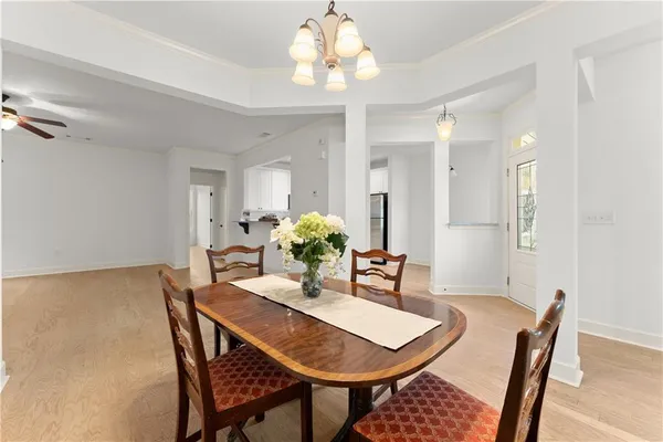 a view of a hallway with chandelier and wooden floor