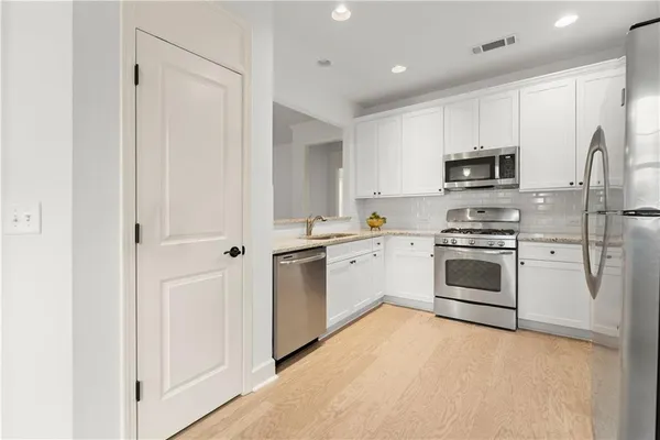 a view of kitchen with white cabinets