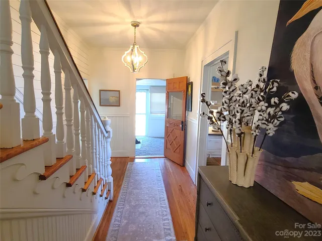 a view of a hallway with wooden floor and staircase