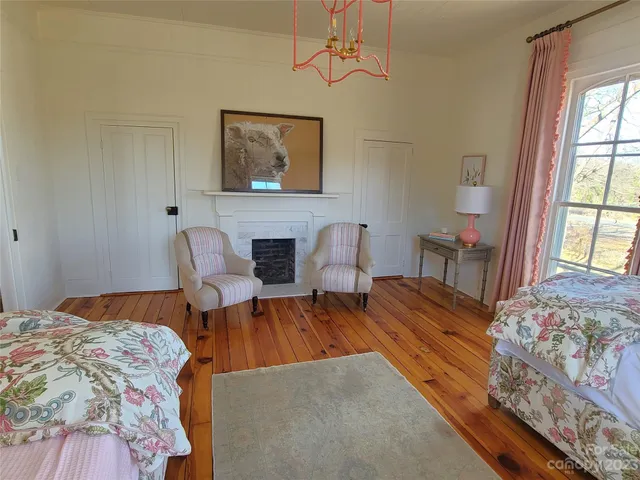 a spacious bedroom with a bed and wooden floor