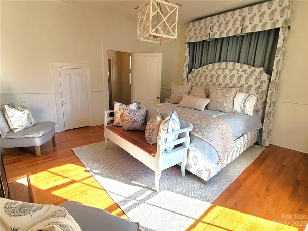a bedroom with a bed a couch and painting on the wall