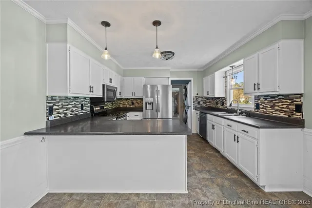 a large kitchen with granite countertop a sink a counter space appliances and cabinets